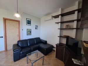 a living room with a black leather couch and a tv at Casa Panorama Assisi in Perugia