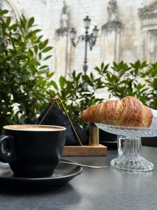 a cup of coffee and a croissant on a table at Holidays House Il Vicoletto in Sulmona