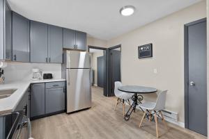 a kitchen with a refrigerator and a table and chairs at Private 1BR for Two on Morganford in Saint Louis