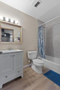 a bathroom with a toilet and a sink and a mirror at Private 1BR for Two on Morganford in Saint Louis