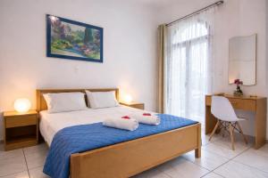 a bedroom with a bed with two towels on it at Natsios Apartments in Vlachopoulátika