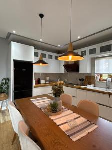 a kitchen with a wooden table with chairs and a dining room at Great Alexander Suites in Sarandë
