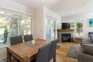 a dining room with a wooden table and a fireplace at 63 Lagoons in Whistler