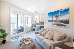 a living room with a couch and a table at Panoramic Views from this gorgeous 2 Bed Property - Village Location in Whistler
