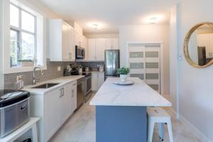 a kitchen with white cabinets and a sink and a counter at Panoramic Views from this gorgeous 2 Bed Property - Village Location in Whistler