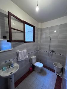 a bathroom with a sink and a toilet and a window at Tabriquet urban shared room in Salé