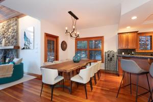 a dining room with a wooden table and white chairs at Luxury 5 Bedroom Blueberry Chalet in Whistler
