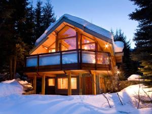 a house in the snow with the lights on at Luxury 5 Bedroom Blueberry Chalet in Whistler