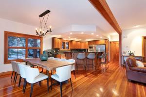 a kitchen and living room with a wooden table and chairs at Luxury 5 Bedroom Blueberry Chalet in Whistler