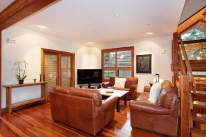 a living room with leather furniture and a tv at Luxury 5 Bedroom Blueberry Chalet in Whistler +26 photos