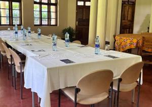 a long table with chairs and bottles of water on it at Kilimanjaro Lodge - MCF in Moshi
