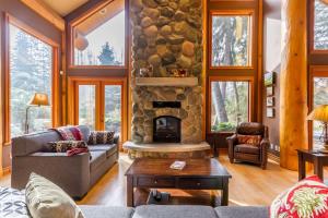 a living room with a fireplace and a stone wall at 8140 Nicklaus North in Whistler