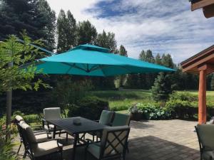 a table and chairs under a large blue umbrella at 8140 Nicklaus North in Whistler
