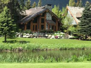 a log cabin with a pond in front of it at 8140 Nicklaus North in Whistler +43 photos