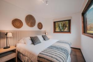 a bedroom with a bed and a window at Cabañas Parque Futangue in Lago Ranco