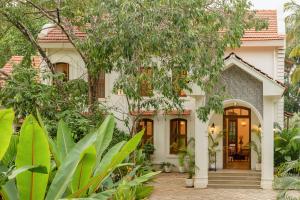 a house with a courtyard and trees at Lohonostays Villa Brisa in Anjuna