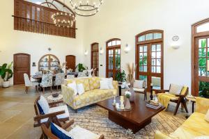 a living room with a yellow couch and a table at Lohonostays Villa Brisa in Anjuna