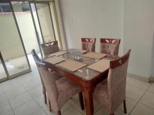 a dining room table with four chairs and a glass door at Casa de 2 pisos en Morales in Morales