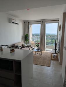 a kitchen and living room with a large window at Exclusivo apartasuite con terraza y vista al mar - Bello Horizonte in Santa Marta