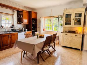 a kitchen with a table and chairs in a kitchen at Casa Nabia - Coastal Sanctuary in Ericeira