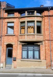 a brick building with windows with curtains in it at Chez Toi Ailleurs - Dinant in Dinant
