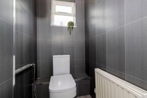a bathroom with a white toilet and a window at 3BR Home in Darlington Contractor Rates in Darlington +11 photos