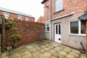 a courtyard with a brick wall and a white door at 3BR Home in Darlington Contractor Rates in Darlington