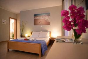 a bedroom with a bed and a vase of flowers at Nikoletta 4 in Vlachopoulátika