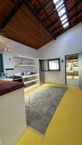 a large room with a yellow floor and a kitchen at Casa Pema - Grupo Casa Camurupim in Barra Grande
