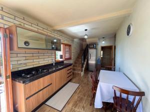 a kitchen with a table with a white table cloth at Morada Paraíso dos Canyons in Praia Grande