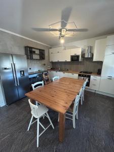 a kitchen with a wooden table and white chairs at Franciacorta Garden House in Cazzago San Martino