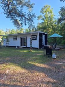a tiny house with a picnic table and an umbrella at Kokomo Farms in Live Oak