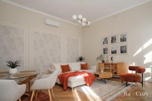 a white living room with a bed and a table at Rá-Cozy in Pécs