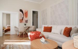 a living room with a white couch and a table at Rá-Cozy in Pécs