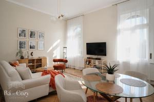 a living room with a couch and tables and a tv at Rá-Cozy in Pécs