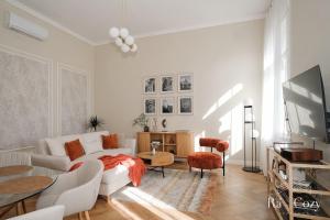a living room with a white couch and a tv at Rá-Cozy in Pécs