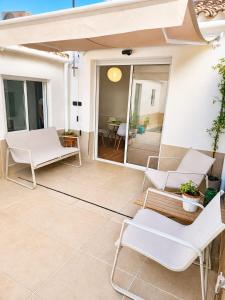 a patio with white chairs and a table at House with a private pool, relaxation guaranteed in Talavera de la Reina