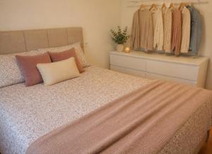 a bedroom with a large bed with pillows and clothes at House with a private pool, relaxation guaranteed in Talavera de la Reina +5 photos