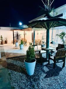 a patio with a table and benches and an umbrella at Apart Piedras con cohera y desayuno seco in Villa María