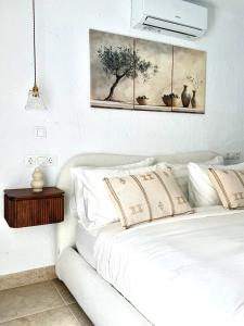a bedroom with a white bed and a painting on the wall at Casa Natali 2 in Fuengirola