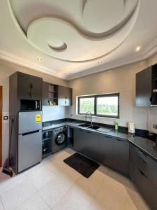 a kitchen with a circular ceiling with a sink and a dishwasher at Les Résidences AKATA-Appartement HOUÈ in Abomey-Calavi