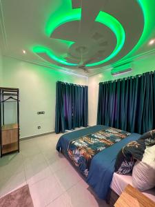 a bedroom with a green ceiling and a bed at Les Résidences AKATA-Appartement HOUÈ in Abomey-Calavi