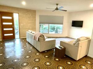a living room with two chairs and a ceiling fan at Emu Bay Bliss 'sweeping ocean views' in Emu Bay