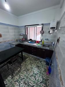 a kitchen with a counter and a sink and a window at Tabriquet urban shared room in Salé +14 photos