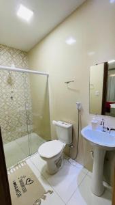 a bathroom with a shower and a toilet and a sink at Pousada Girassol in Piranhas +39 photos