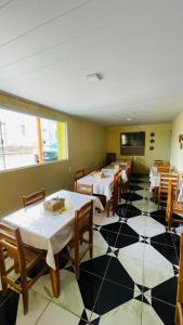 a restaurant with tables and chairs and a tiled floor at Pousada Girassol in Piranhas