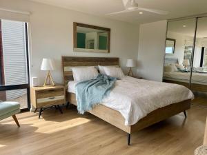 a bedroom with a large bed and a mirror at Stokes Bay Cliffs Kangaroo Island in Stokes Bay