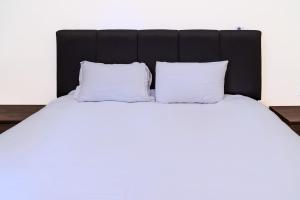 a bed with white pillows and a black headboard at COZY APPARTEMENT Center city 11 janvier in Casablanca