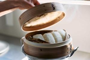 a person is putting a wooden spoon into a pot of food at 一組限定の宿 季の間 Private Traditional House & Tea Experience in Nagano in Iida