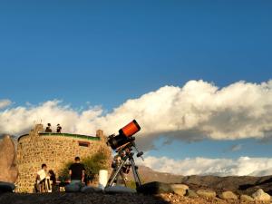 a tripod with a camera and people on top of a building at Alojamiento y Refugio Cósmico Torreon in Comunidad Campo de Ahumada